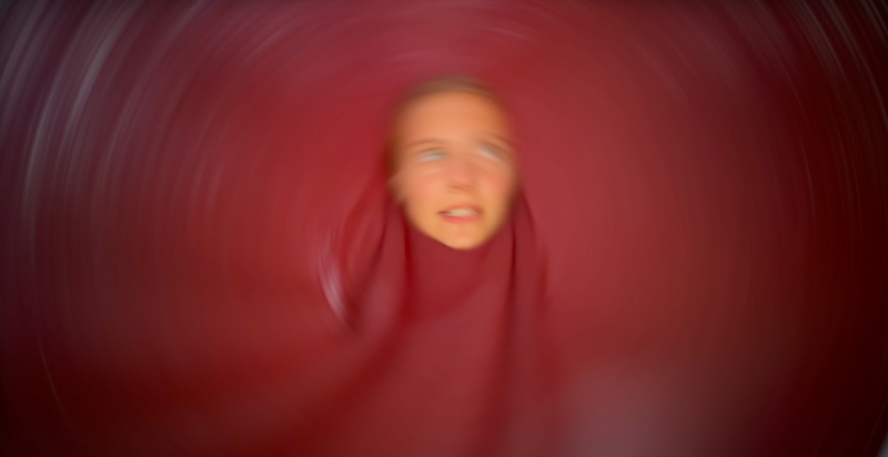 Junges verschwommenes Gesichz vor unscharfem rotem Hintergrund